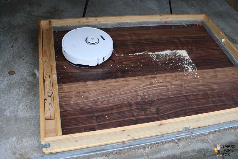 Roborock S8 Pro Ultra reinigt Haferflocken im Saugtest auf einem Hartboden.